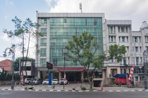 a large building with cars parked in front of it at Urbanview Hotel Newton Riau Bandung by RedDoorz in Bandung