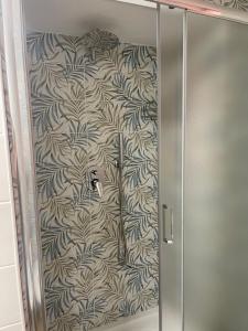 a shower stall with a wall with a floral wallpaper at BeB sott o pont Napoli in Naples