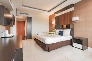 a hotel room with a bed and a television at Urbanview Hotel Newton Riau Bandung by RedDoorz in Bandung