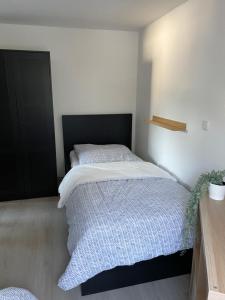 1 dormitorio con 1 cama con edredón blanco en - SANO Apartments - bei Uwe, en Hagen