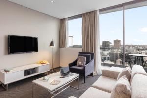 sala de estar con sofá y TV en Meriton Suites Campbell Street, Sydney en Sídney