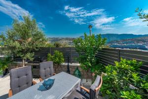 einen Tisch und Stühle auf einem Balkon mit Aussicht in der Unterkunft Apartment One B with Heated Outdoor pool in Dubrovnik