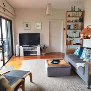 a living room with a couch and a tv at Maggie's Place in Cowes in Cowes
