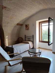 1 dormitorio con 2 camas, mesa y ventana en Masseria Galleppa - Rooms, Pool and Relax, en Monopoli