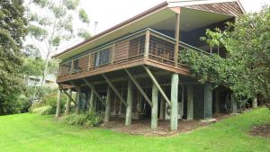 a house with a deck on the side of it at Ravensbourne Escape - Cedar Lodge in Ravensbourne