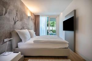 a bedroom with a bed with a stone wall at Luxury Apartment Jesolo in Lido di Jesolo