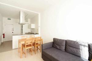 a living room with a couch and a table and chairs at Apartamento Ayla San Fermín in Pamplona