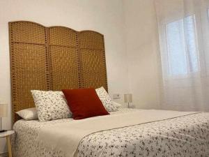 ein Bett mit einem großen Kopfteil in einem Schlafzimmer in der Unterkunft Apartamento Ayla San Fermín in Pamplona
