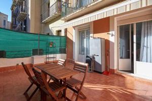 einen Holztisch und zwei Stühle auf einer Terrasse in der Unterkunft Apartamento Ayla San Fermín in Pamplona