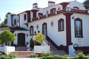 a large white house with red trim at Moinho Do Álamo in Montemor-o-Novo