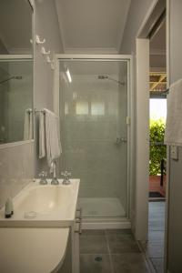 a bathroom with a shower, sink, and tub at 22 On Bowen in Roma