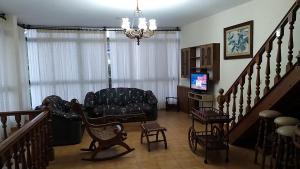 sala de estar con sofá y escalera en Casa con Piscina en Ramiras, Ourense, en Santo Tomé