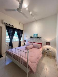 Schlafzimmer mit einem Bett mit rosa Bettwäsche und einem Fenster in der Unterkunft Eira Homestay Lost World Of Tambun M uslim only in Ipoh