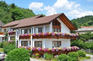 a house with flowers on the side of it at Hotel-Pension Breig Garni in Ottenhöfen