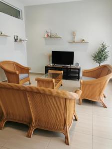 a living room with a couch and chairs and a tv at 28 Residence Homestay in Melaka
