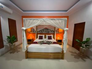 1 dormitorio con cama con dosel y paredes de color naranja en Ubud mesari Private Pool Villa, en Ubud