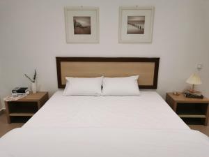 a bedroom with a large white bed with two tables at 28 Residence Homestay in Melaka