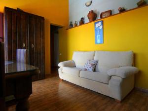 a living room with a white couch and a yellow wall at Casa Goliath in Isora