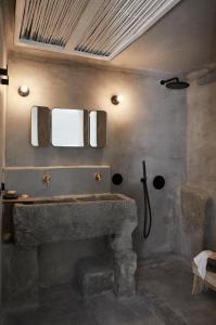 a bathroom with a stone fireplace and a sink at Santa Irini Retreat in Thirasia