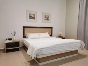 a bedroom with a large bed with white sheets at 28 Residence Homestay in Melaka