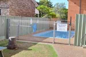 a metal fence with a pool in a yard at Cameo Court 1 in South West Rocks