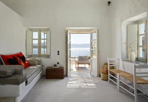 a living room with a couch and a view of the ocean at Santa Irini Retreat in Therasia