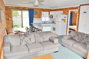 a living room with a couch and a kitchen at Cameo Court 2 in South West Rocks