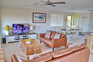 a living room with a couch and a tv at Carrington 6 in South West Rocks