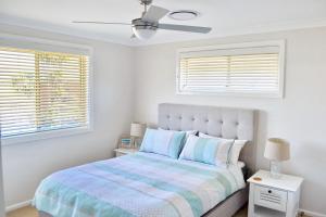 a bedroom with a bed and two windows at Carrington 6 in South West Rocks