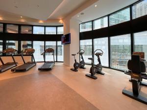 ein Fitnessstudio mit Laufbändern und Crosstrainern in einem Raum mit Fenstern in der Unterkunft 72 floor 2BR at the Address JBR with Marina Views! in Dubai