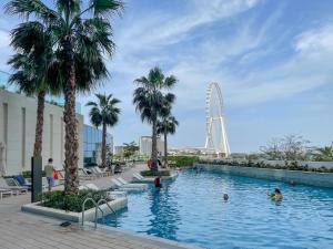 ein Schwimmbad mit einem Riesenrad im Hintergrund in der Unterkunft 72 floor 2BR at the Address JBR with Marina Views! in Dubai