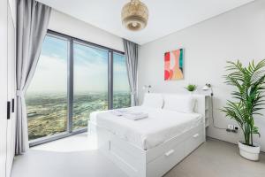 ein weißes Schlafzimmer mit einem weißen Bett und großen Fenstern in der Unterkunft 72 floor 2BR at the Address JBR with Marina Views! in Dubai + 18 Fotos
