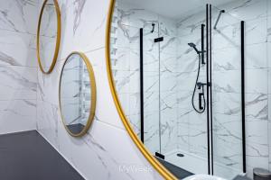 La salle de bains est pourvue de deux miroirs et d'une douche. dans l'établissement Apartamenty Na Szlaku, MyWeek, à Kłodzko
