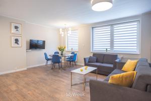 salon z kanapą i stołem w obiekcie Apartamenty Na Szlaku, MyWeek w Kłodzku