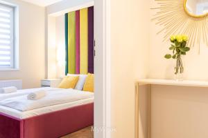 Pokój z łóżkiem i wazą kwiatów w obiekcie Apartamenty Na Szlaku, MyWeek w Kłodzku