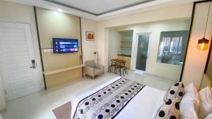 a bedroom with a bed and a flat screen tv at Ultimate Residence Bali in Denpasar