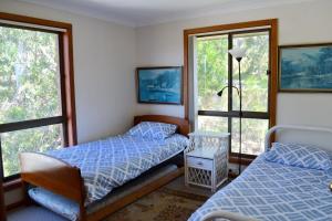 a bedroom with two beds and two windows at Dalesview Retreat in Arakoon