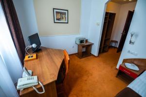 a room with a desk with a phone on it at Emerald Boutique Hotel in Târgu-Mureş