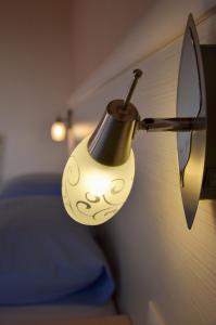a lamp hanging from the side of a bed at Sunset Hotel in Agios Ioannis Kaspaka