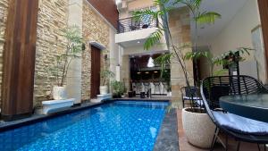 a swimming pool in a house with a table and chairs at Ultimate Residence Bali in Denpasar