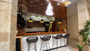 a bar with four stools sitting at a counter at Ultimate Residence Bali in Denpasar