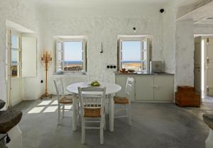a kitchen and dining room with a table and chairs at Santa Irini Retreat in Thirasia