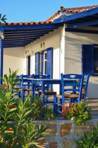 a group of blue chairs in front of a house at Sunset Hotel in Agios Ioannis Kaspaka