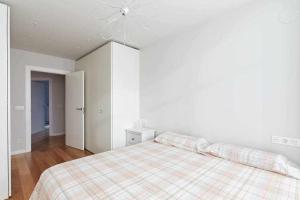 - une chambre blanche avec un lit et une couverture tressée dans l'établissement Apartamento Singular Deluxe, à Pampelune
