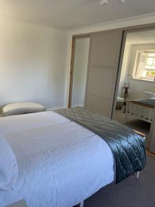 a bedroom with a large white bed and a window at Pretty Ground Cottage in Comrie in Comrie