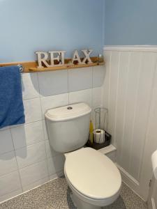 a bathroom with a white toilet in a room at Pretty Ground Cottage in Comrie in Comrie