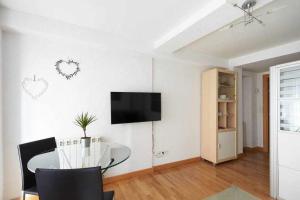a living room with a table and a tv on the wall at Apartamento Ayla Ayuntamiento in Pamplona