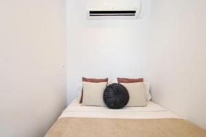 un letto in una camera bianca con cuscini sopra di Phaedrus Living - Seaside Luxury Flat Harbour 104 a Paphos