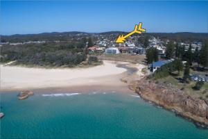 an overhead view of a beach with a plane flying over it at Watermark Apartment 2 - Bring your own linen. in South West Rocks