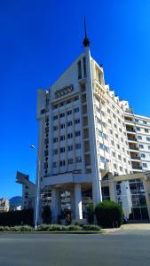 Un grand hôtel blanc avec une croix en haut dans l'établissement Hotel Mara, à Baia Mare
